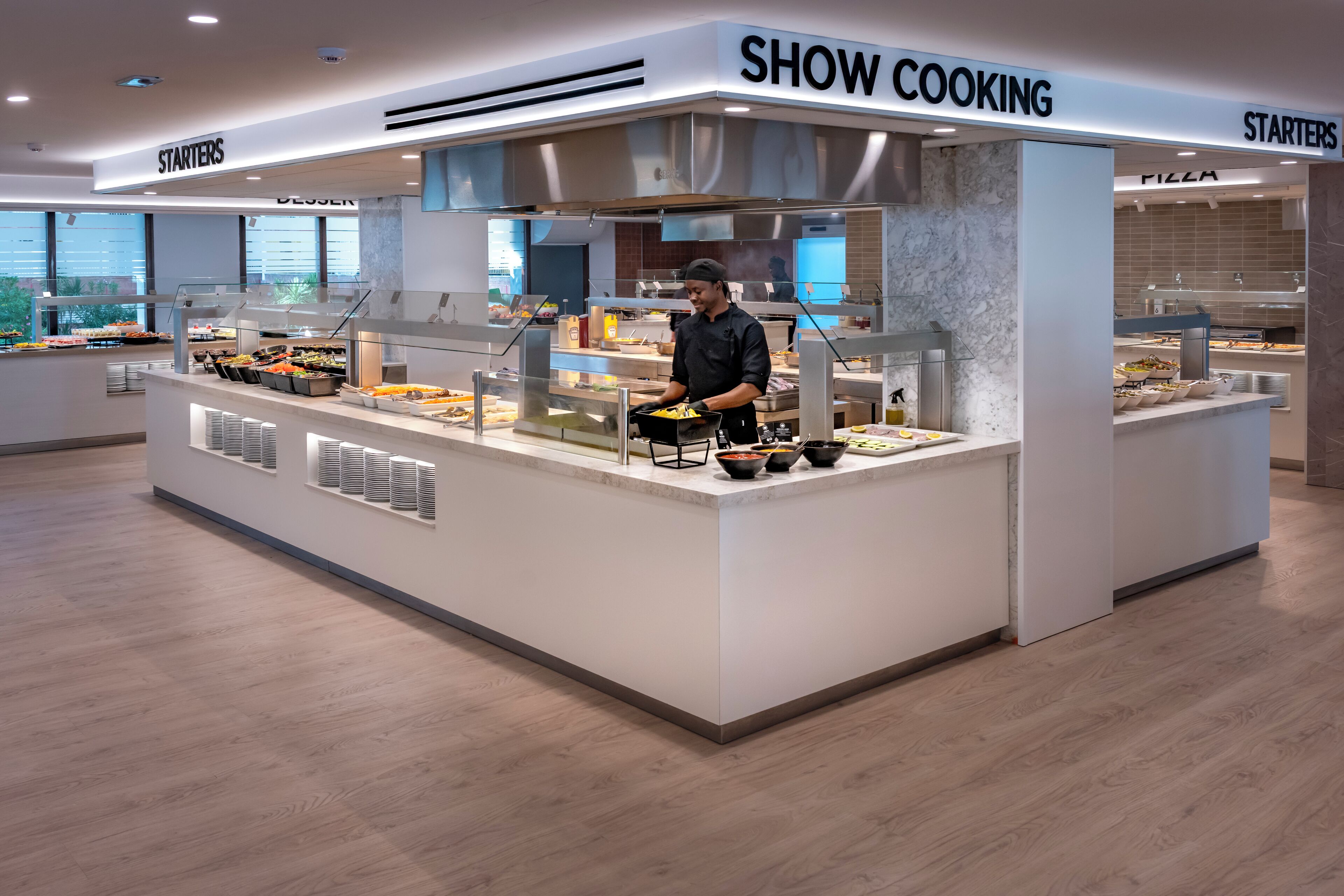 Un espace buffet avec des sections clairement indiquées pour les entrées, les desserts et les pizzas.