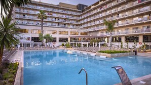 Un hôtel doté d'une grande piscine, de nombreux balcons et d'espaces extérieurs aménagés pour se détendre.
