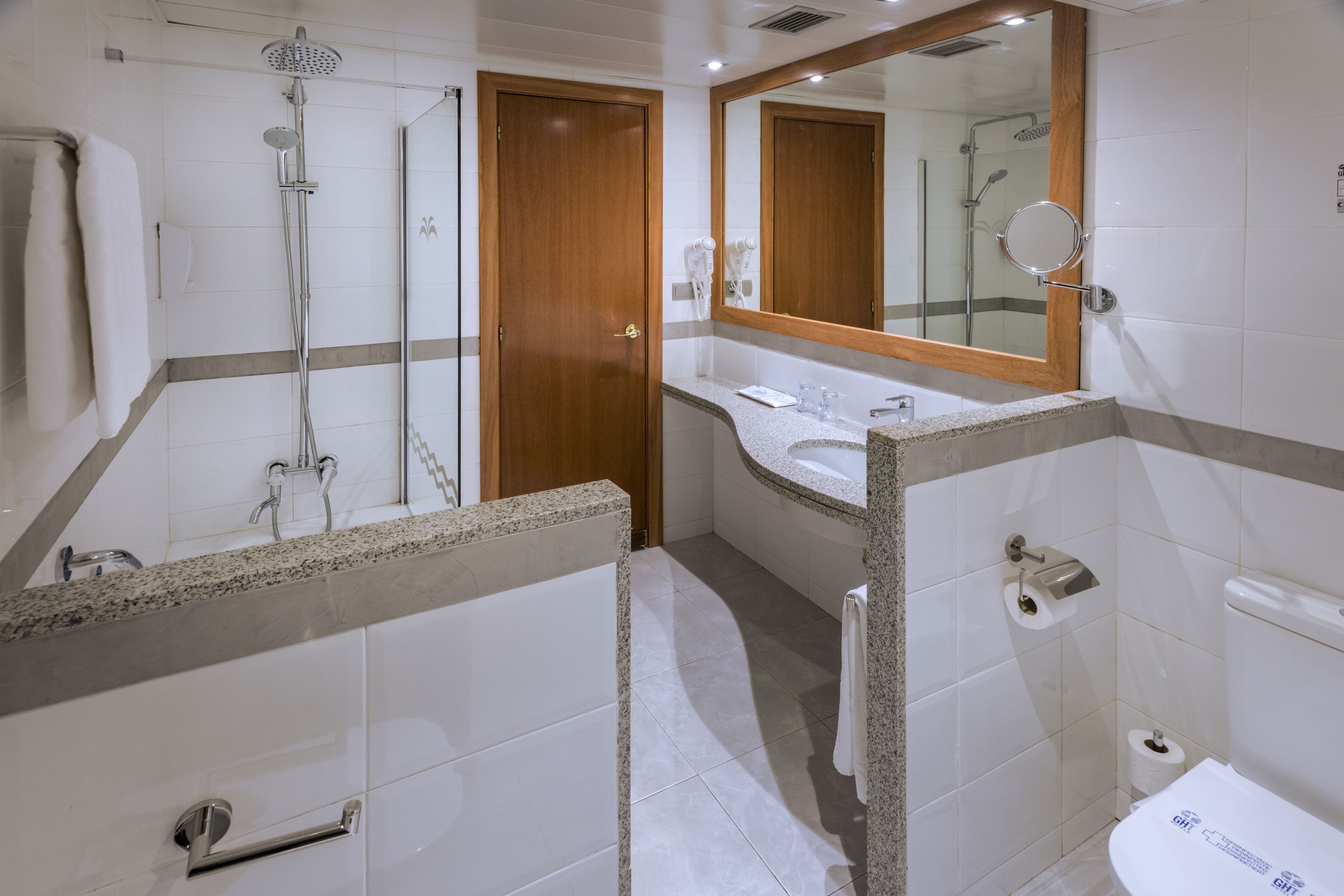 A modern bathroom with a shower, toilet, and sink.