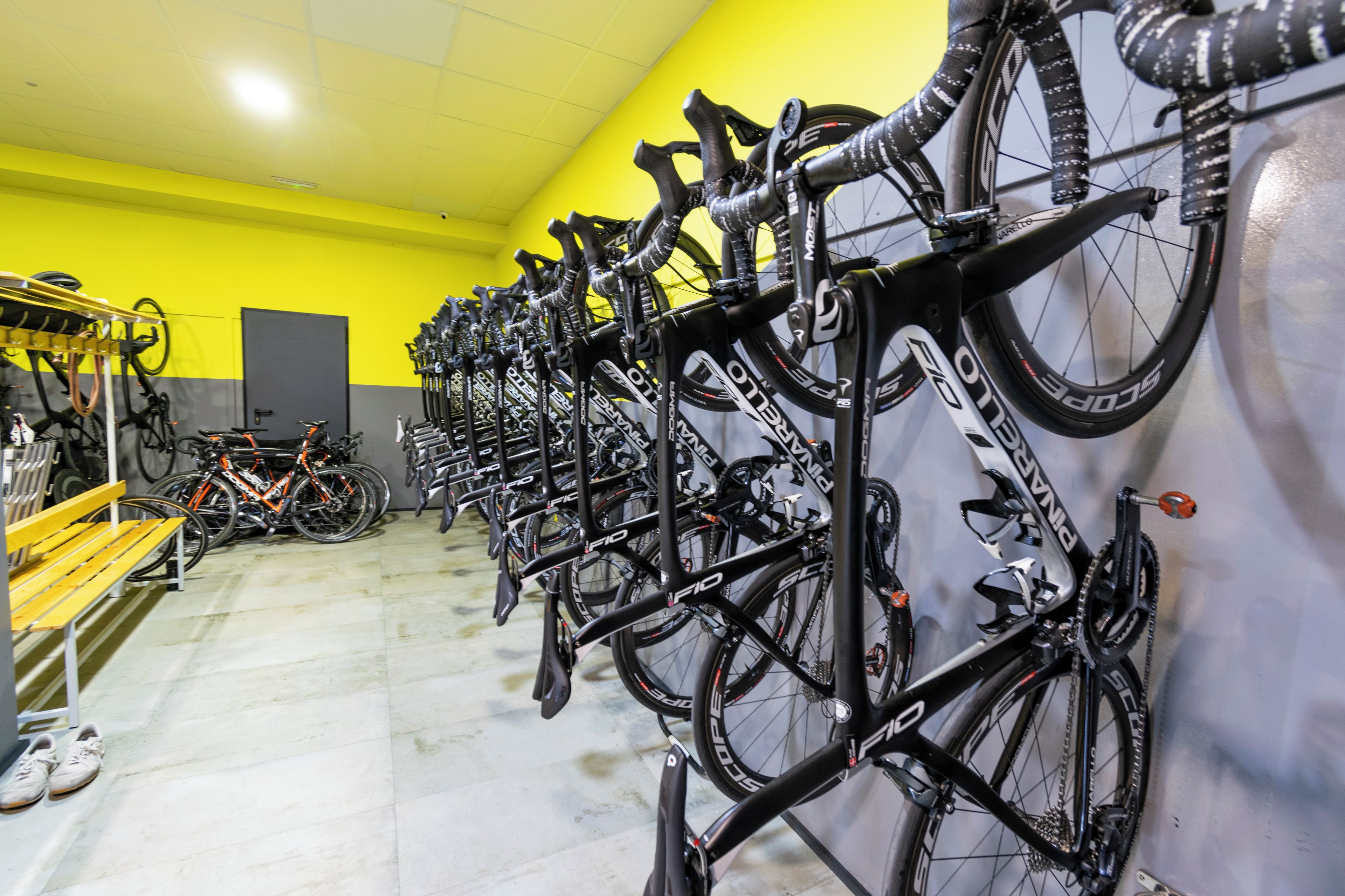 A bike rental station with multiple bicycles and a bench.