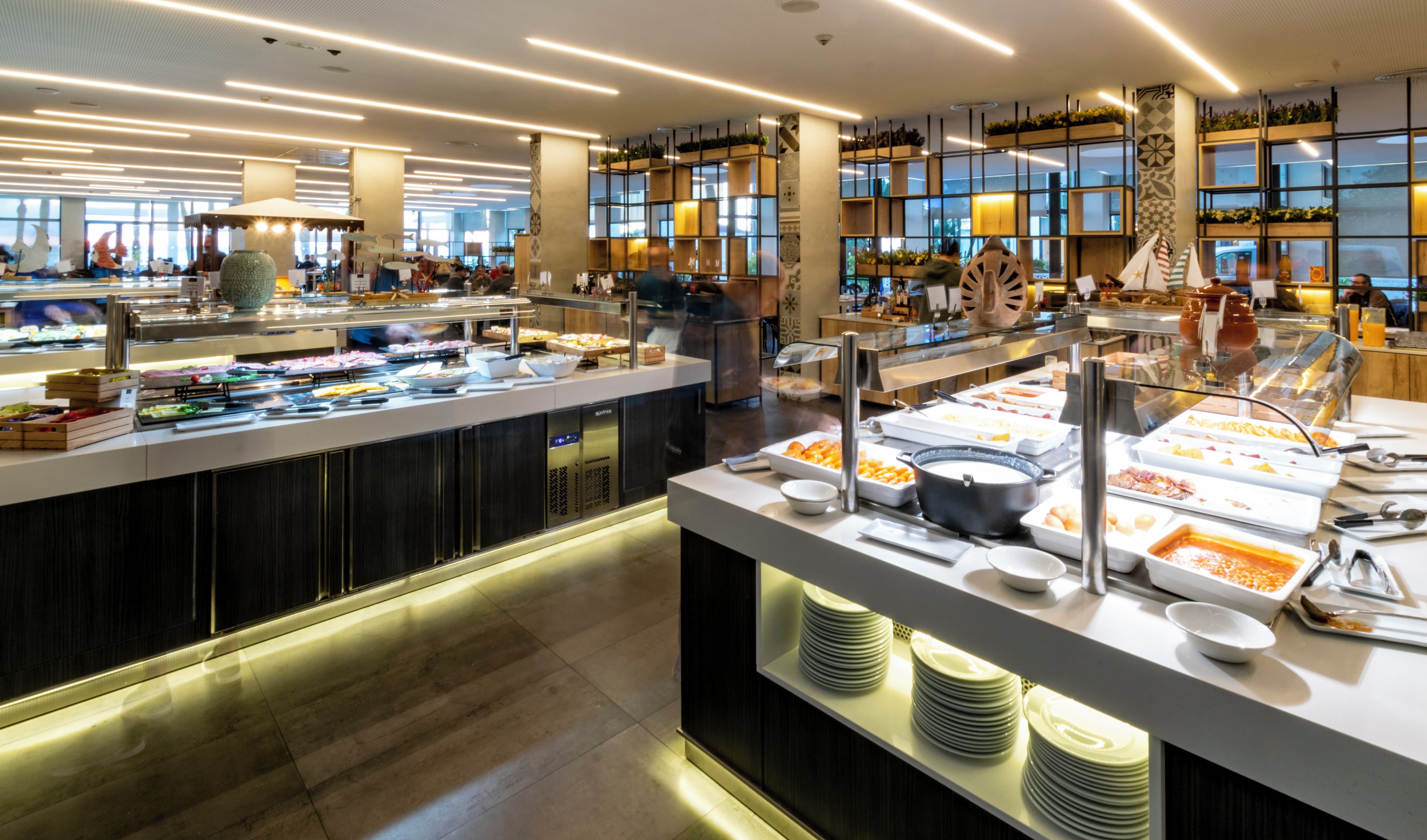 Ein Buffet mit verschiedenen Speiseauslagen, einer Sitzgelegenheit und einem modernen Interieur.