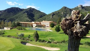 A golf course with a building in the background. - La Figuerola Hotel & Restaurant (Vandellos i l'Hospitalet de l'Infant)