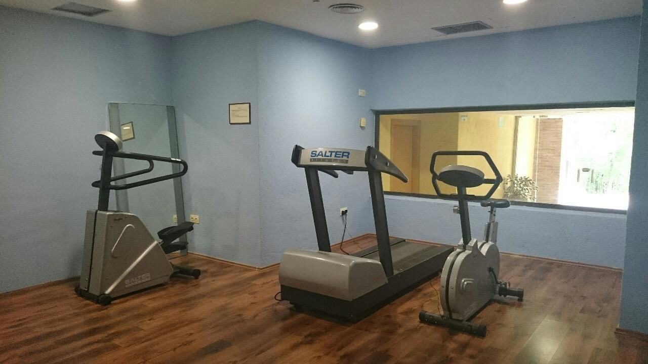 Ein Fitnessraum mit Laufband, Crosstrainer und Ergometer.