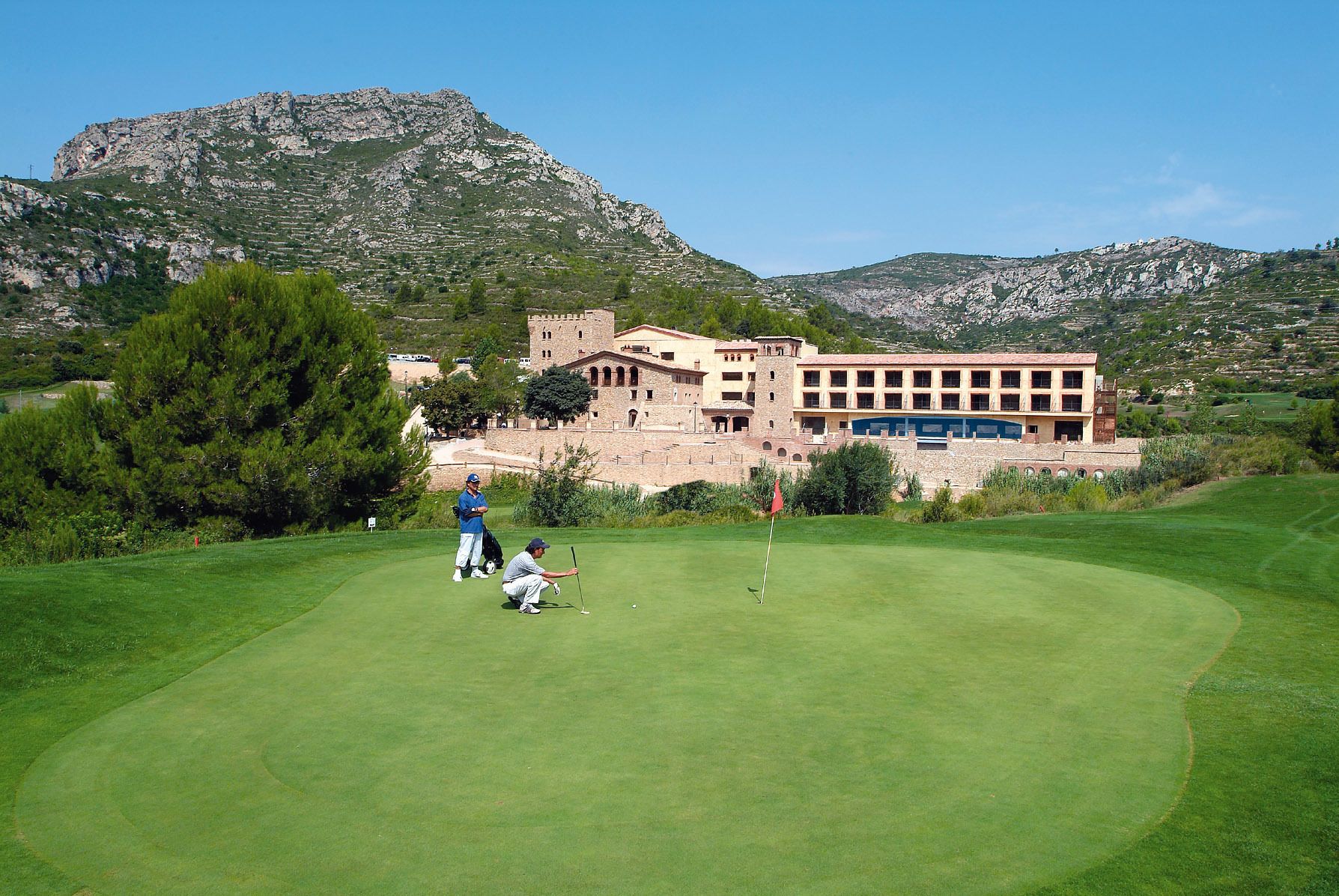 A golf course with a building in the background.