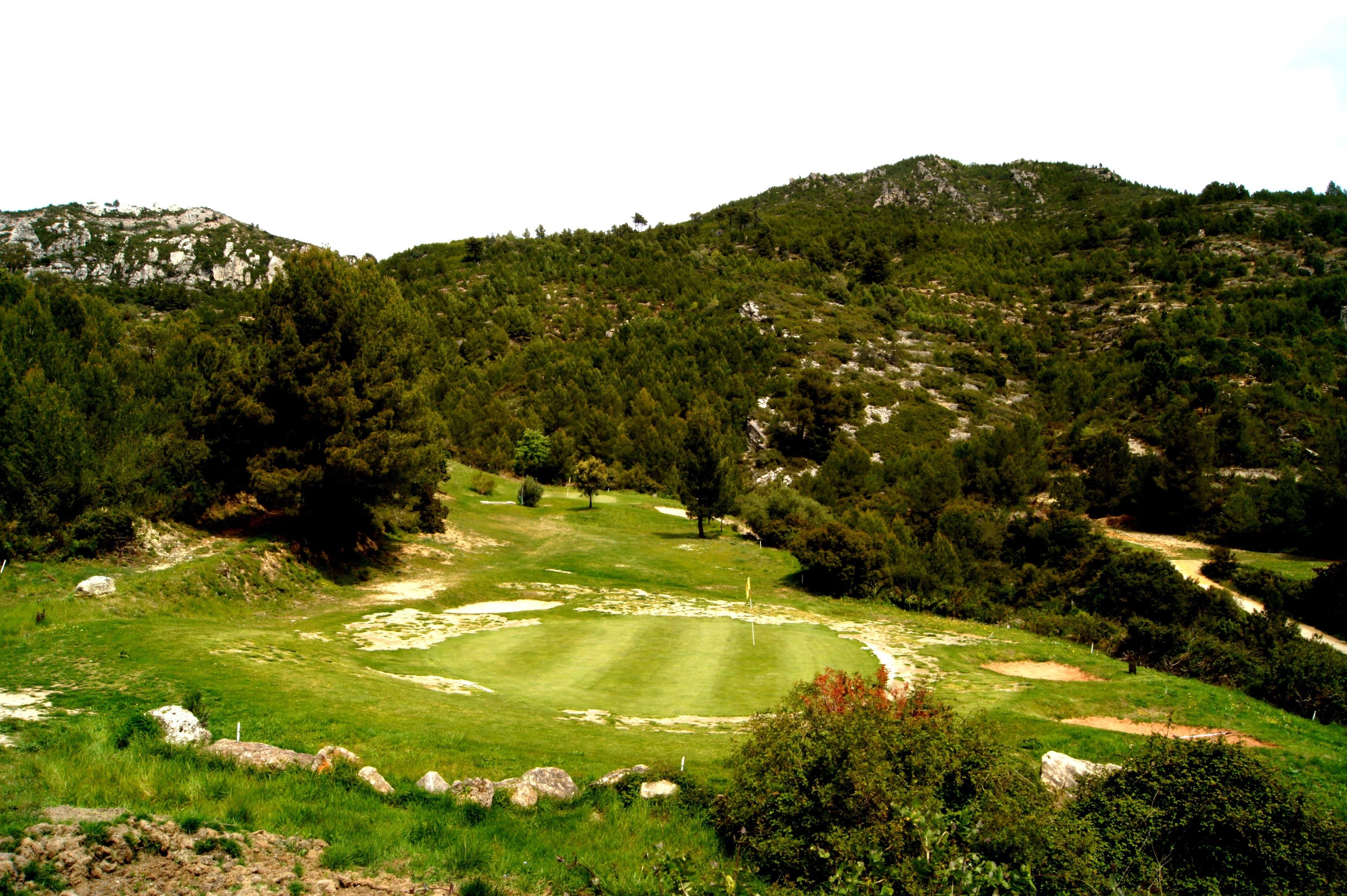Un campo de golf con un green bien cuidado, búnkeres de arena y un marcador de posición.