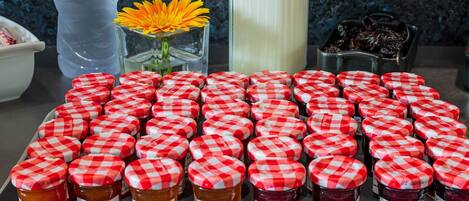A tray of jars with red and white checkered lids, labeled with various fruit names and weights.