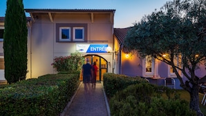 A building with a sign reading "ENTREE" and a pathway leading to the entrance.