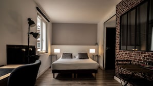 Un dormitorio con una cama grande, mesitas de noche, un escritorio y una silla.