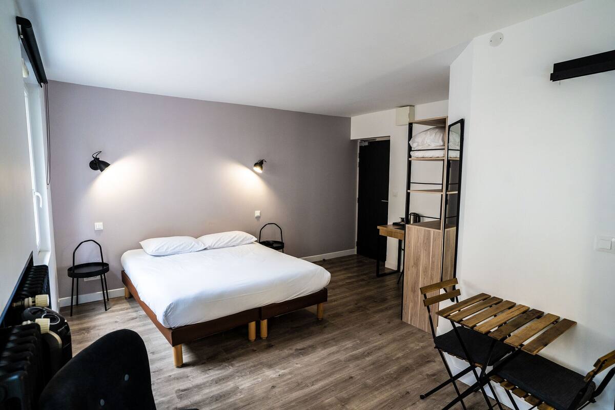 A bedroom with a bed, a desk, a chair, and a wardrobe.