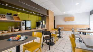 En moderne café med en grøn disk, gule stole og et udvalg af morgenmadsprodukter.