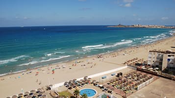 Playa en los alrededores, sombrillas y toallas de playa 