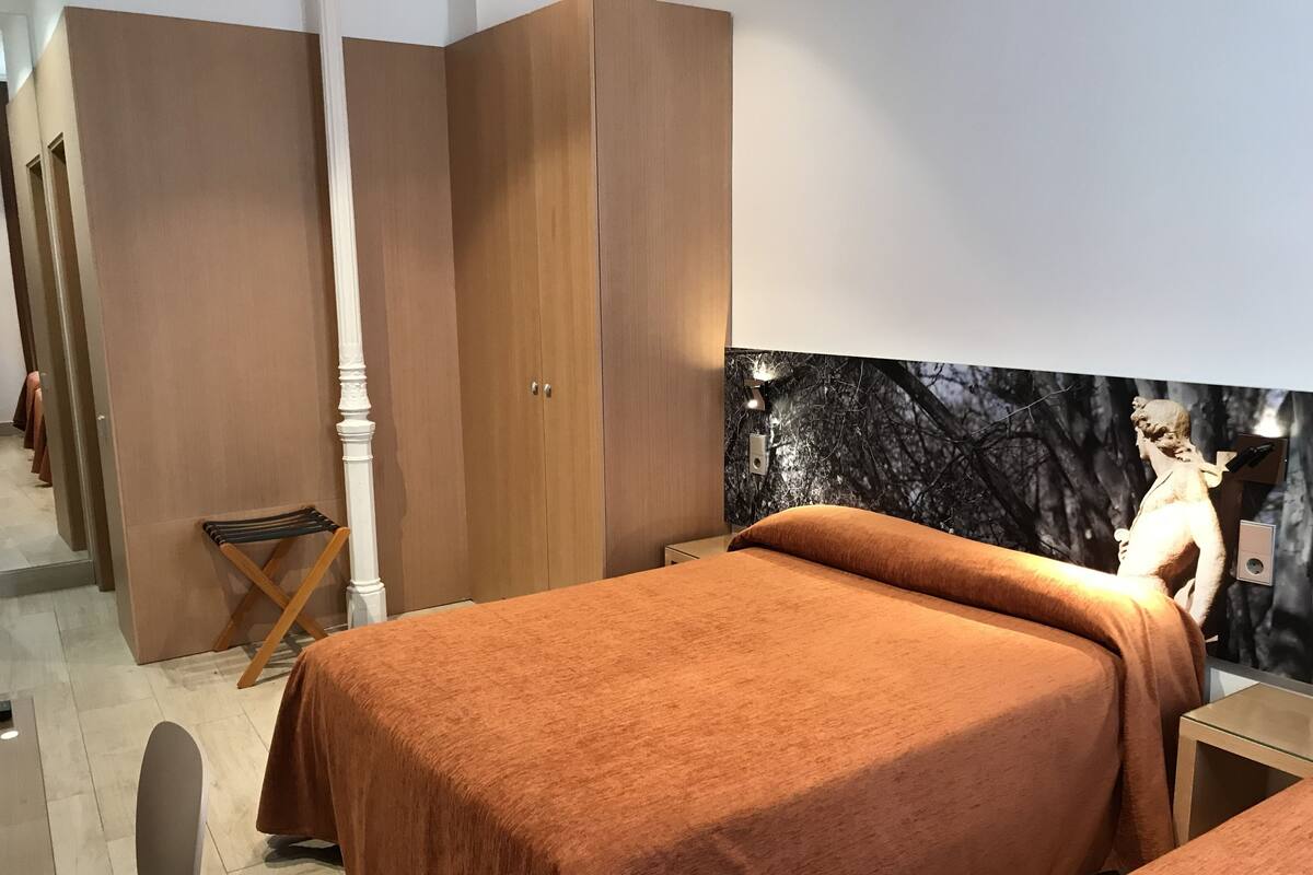 A bedroom with a bed, a wardrobe, and a nightstand.