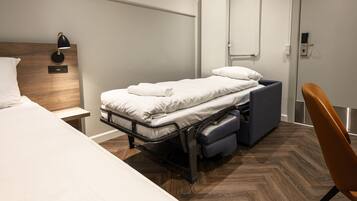 Habitación compacta y moderna con cama, escritorio y silla.