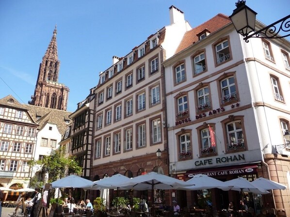 A historic building with a cafe named 'Cafe Rohan' on the ground floor, featuring outdoor seating with umbrellas. - Hotel des Arts (Strasbourg)