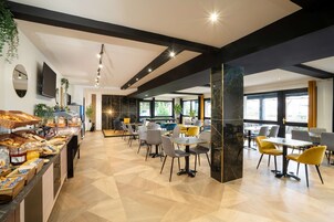 Un comedor moderno con servicio de buffet, varias mesas y sillas.
