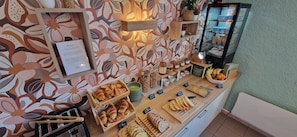 A breakfast buffet with croissants, bread, and jams.