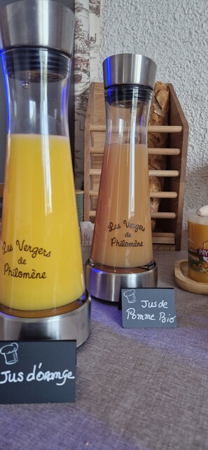 Three glass containers with different colored liquids, each labeled with a name. There are also small chalkboard signs with names of dishes.