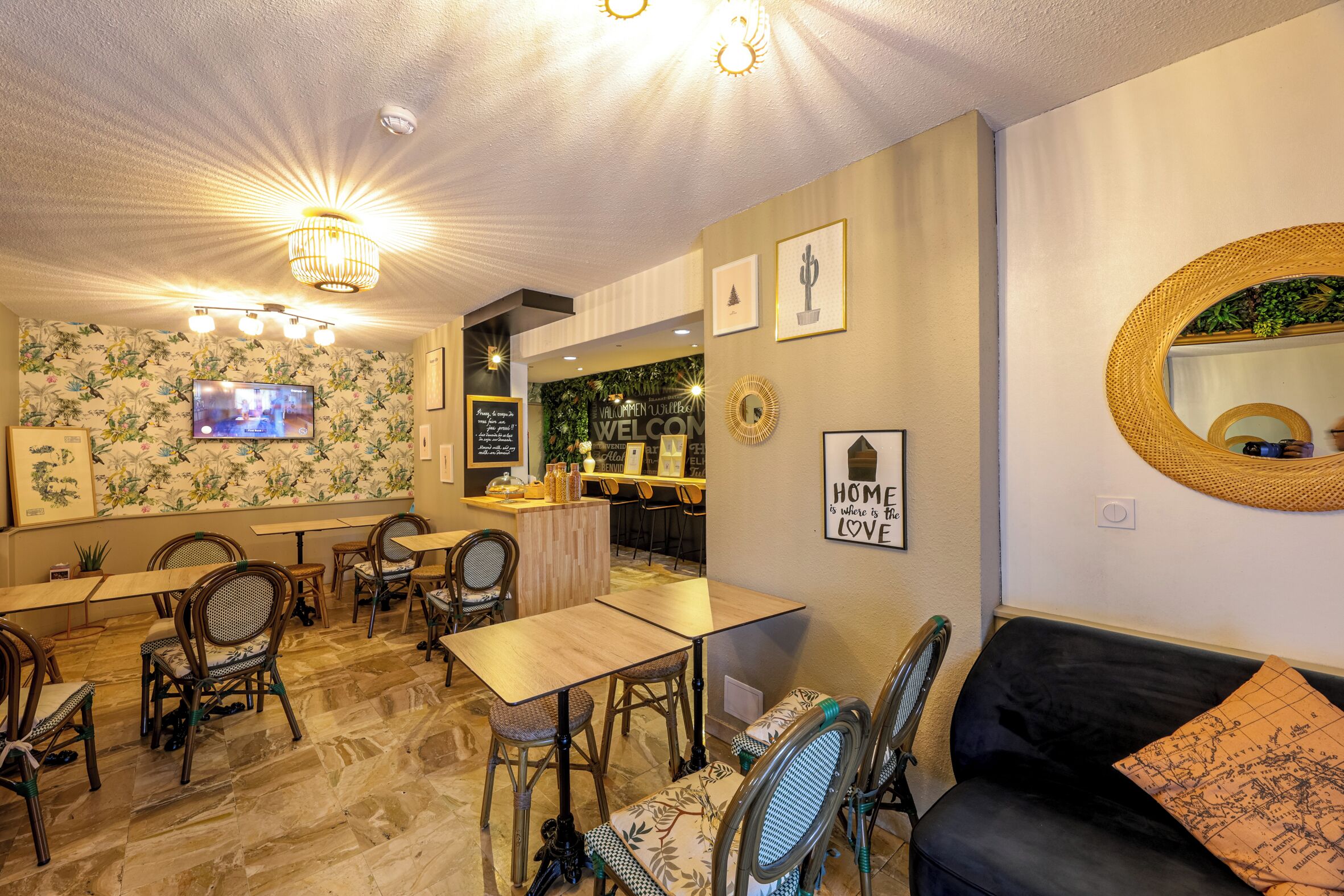Un vestíbulo de hotel con mostrador de recepción, zona de estar y una pantalla de televisión.