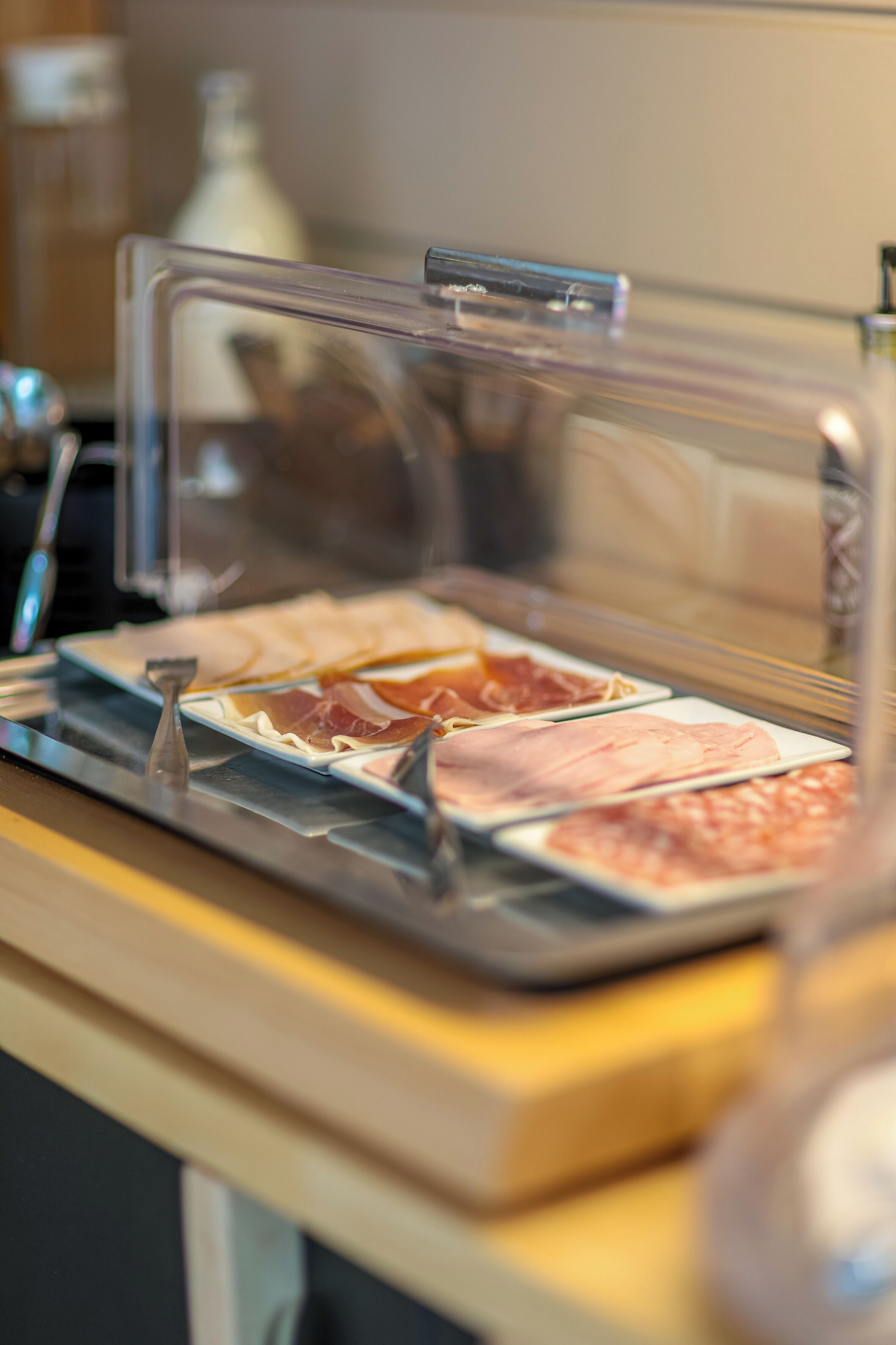 A buffet with various meats and cheeses.