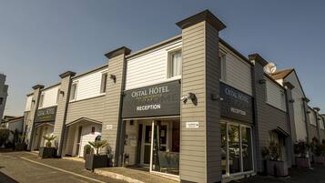 A hotel with a reception area, a sign indicating it's the Ostal Hotel, and a sign for the reception.