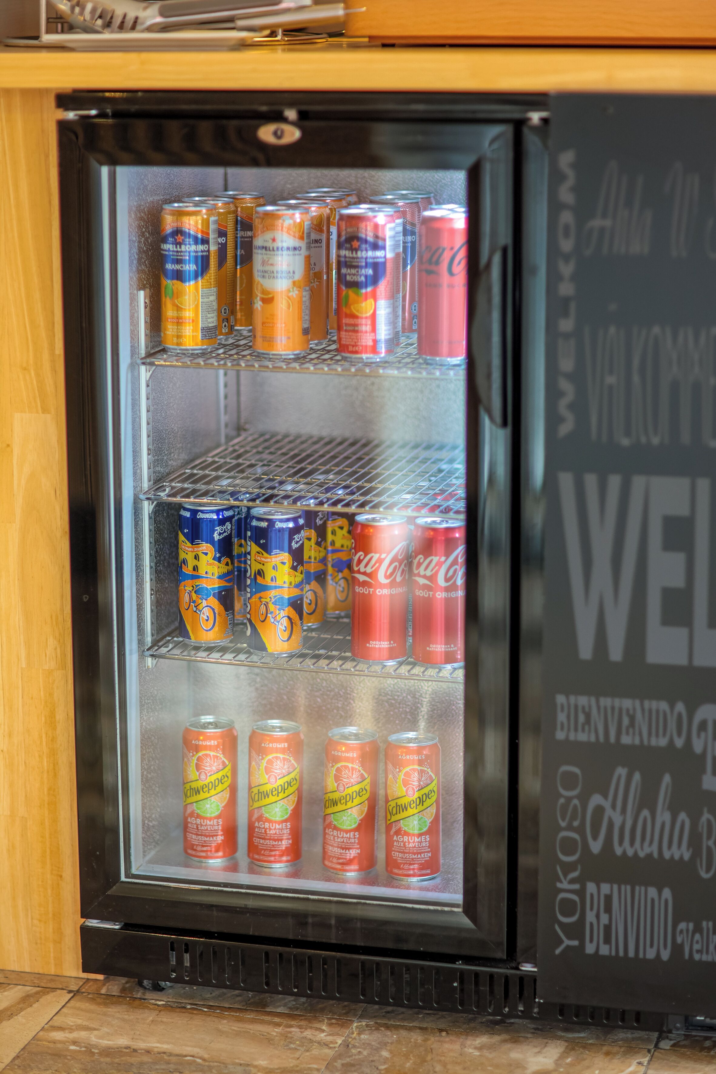 Nevera plena de llaunes de Schweppes i Coca-Cola.