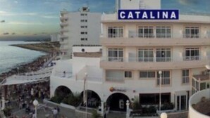 Un bâtiment sur lequel on peut lire l’inscription « CATALINA », avec une plage en arrière-plan.