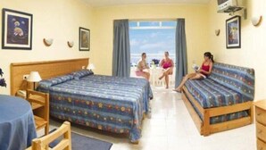 Une chambre d’hôtel avec deux lits, une télévision et un balcon offrant une vue.