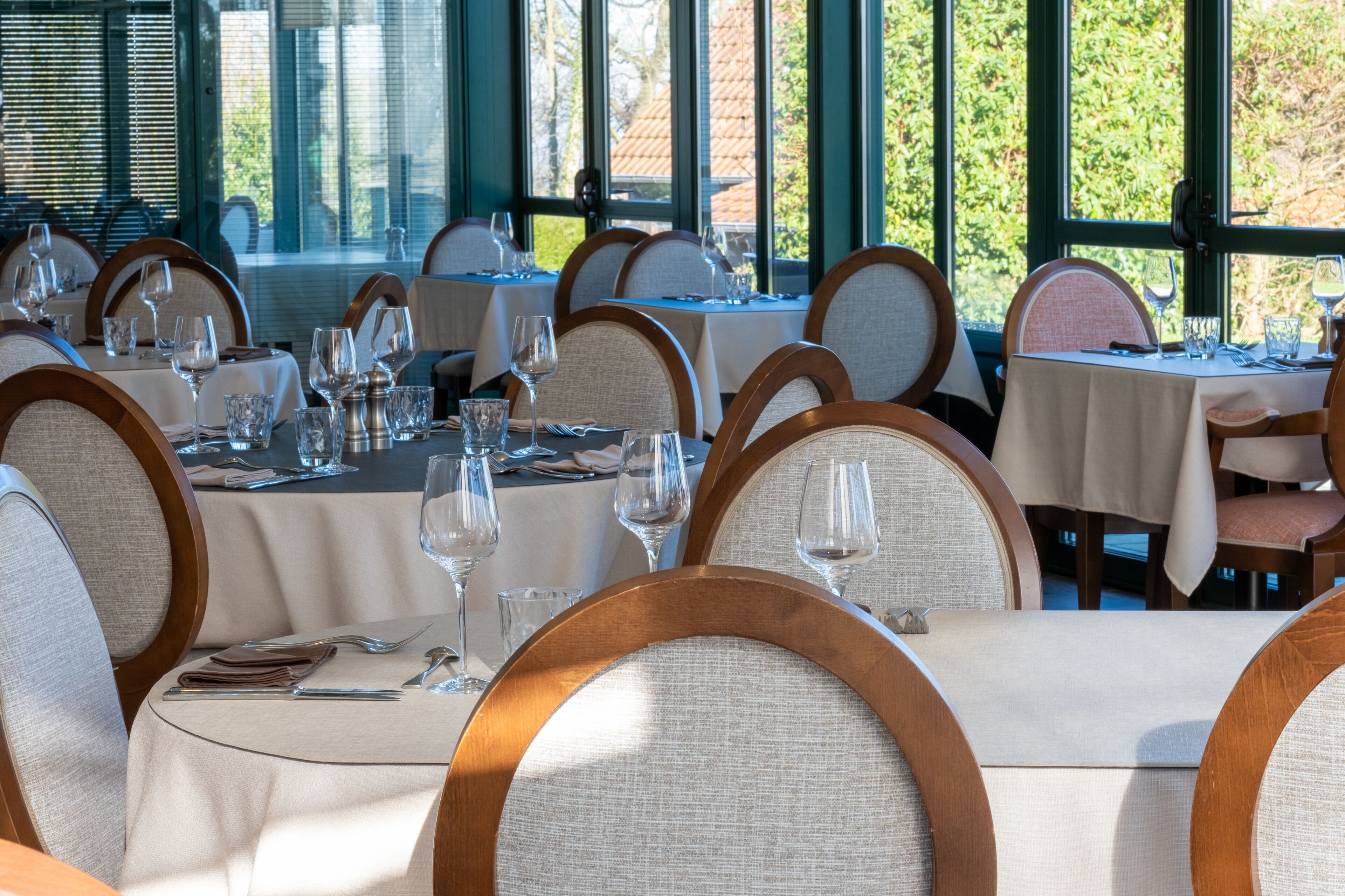 A restaurant with round tables and chairs, set for dining.