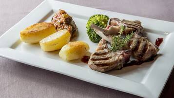 Un plato rectangular blanco con un bistec, papas asadas y brócoli.