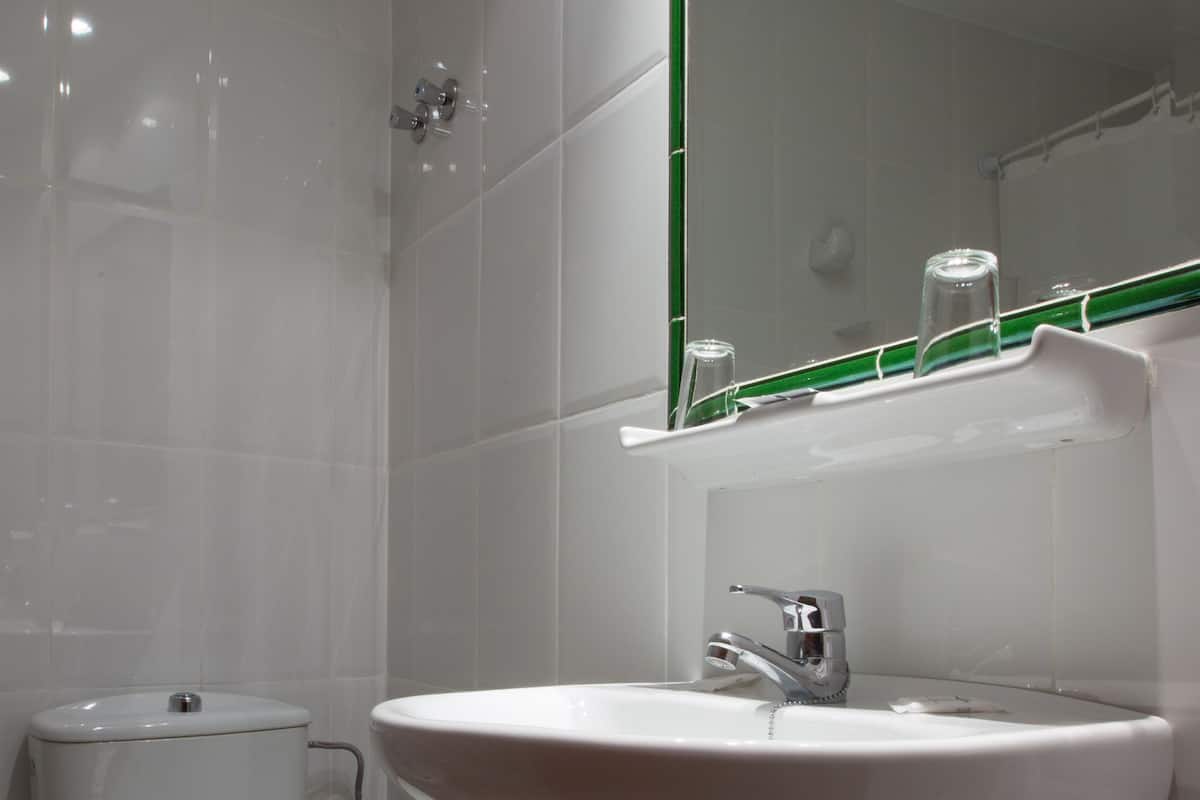 Un baño con inodoro, lavabo y espejo.