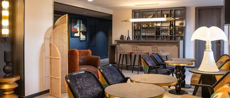 A modern bar area with round tables, bar stools, and a well-lit interior.