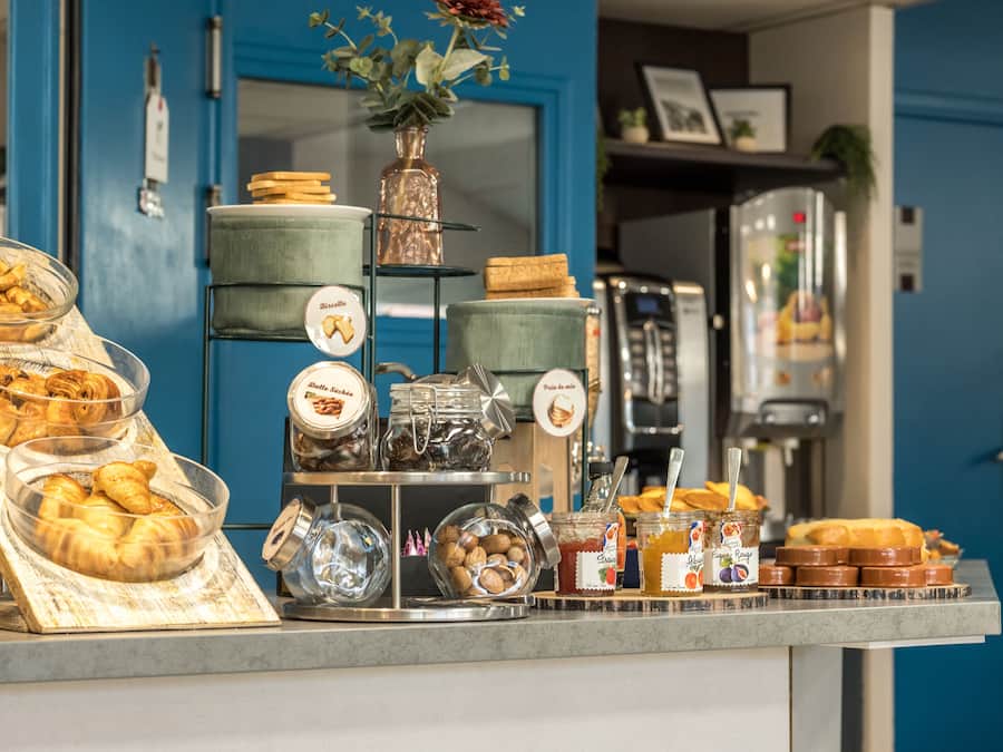 Un buffet de petit-déjeuner proposant un assortiment de viennoiseries, de sandwichs et de condiments.