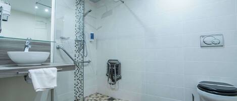 A modern bathroom with a glass shower enclosure, a sink with a mirror, and a toilet.