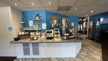 A hotel reception area with a counter, various amenities, and a blue wall.