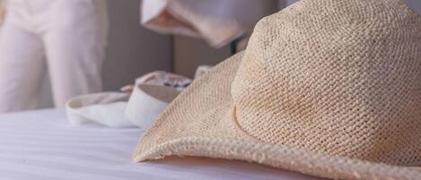A bed with a straw hat and a white pillow.