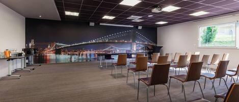A conference room with a large window, a carpeted floor, and a wall mural of a bridge.