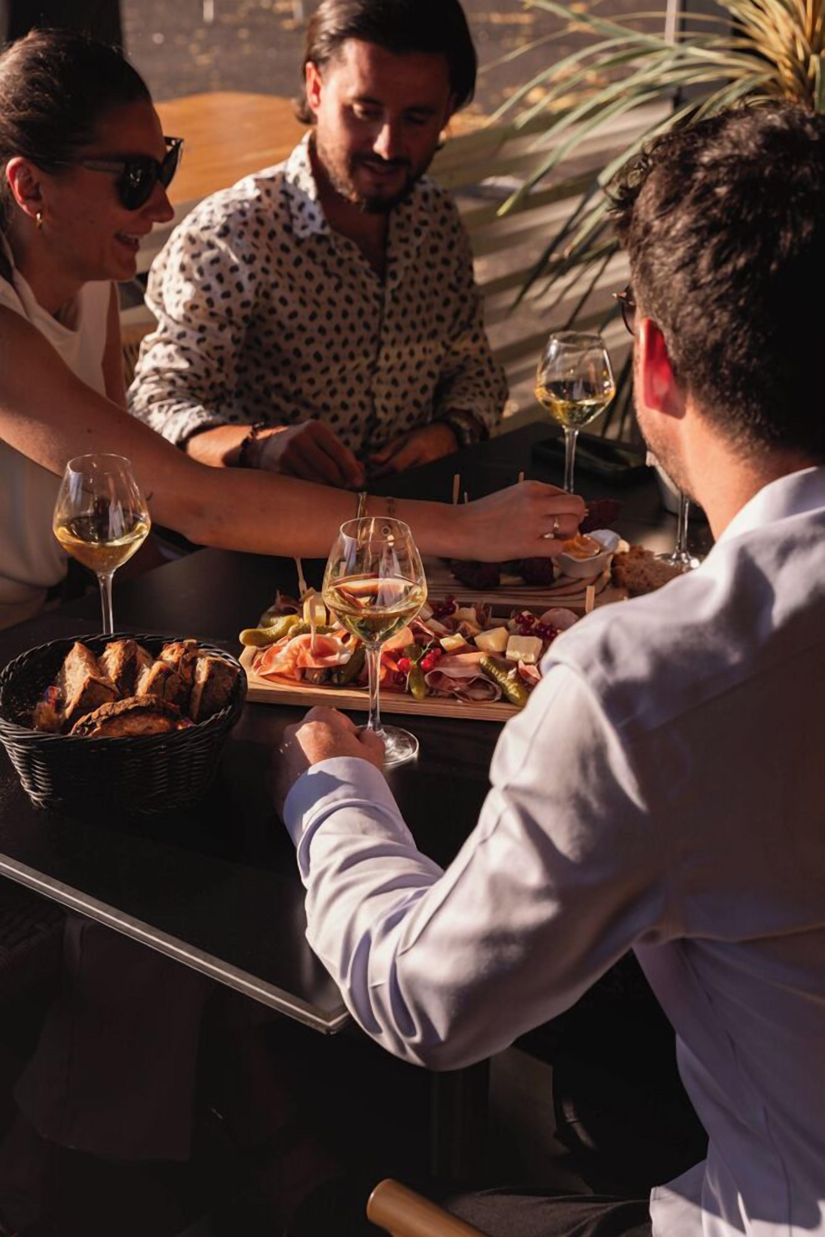 Een eettafel met diverse soorten eten en wijnkaraffen.
