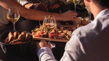 Een eettafel met diverse soorten eten en wijnkaraffen.