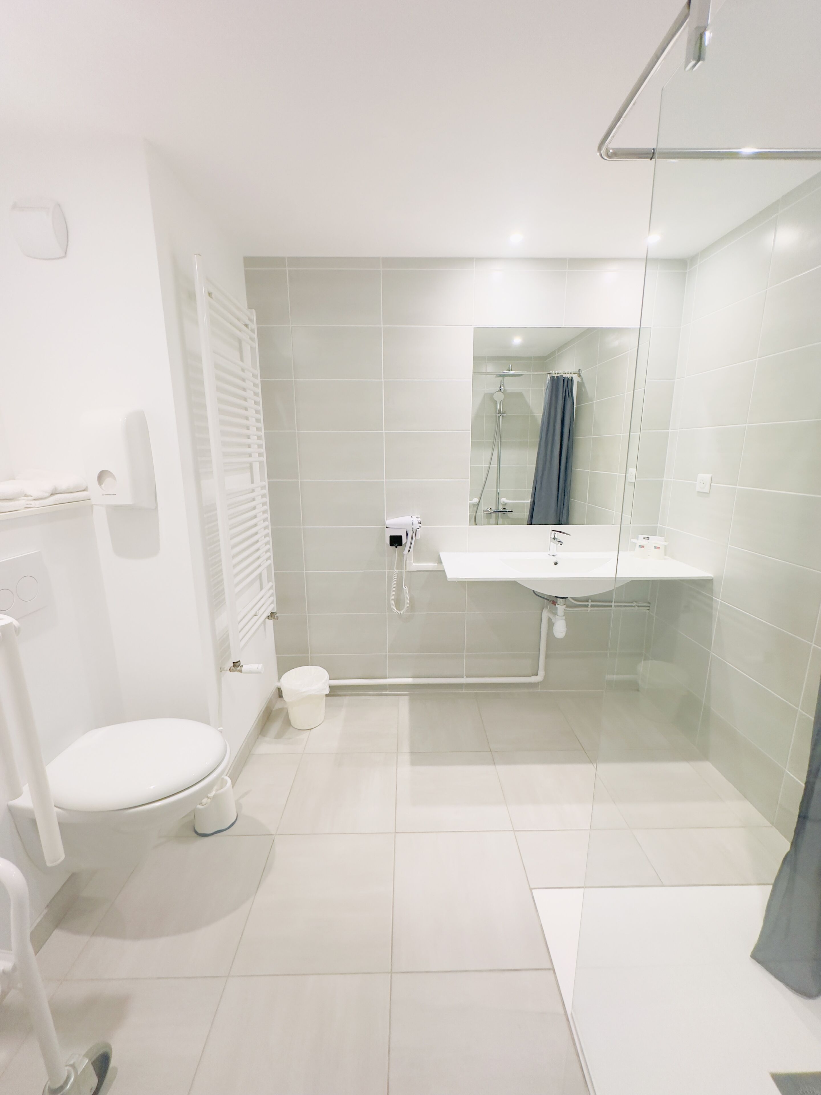 A modern bathroom with a toilet, sink, and shower.
