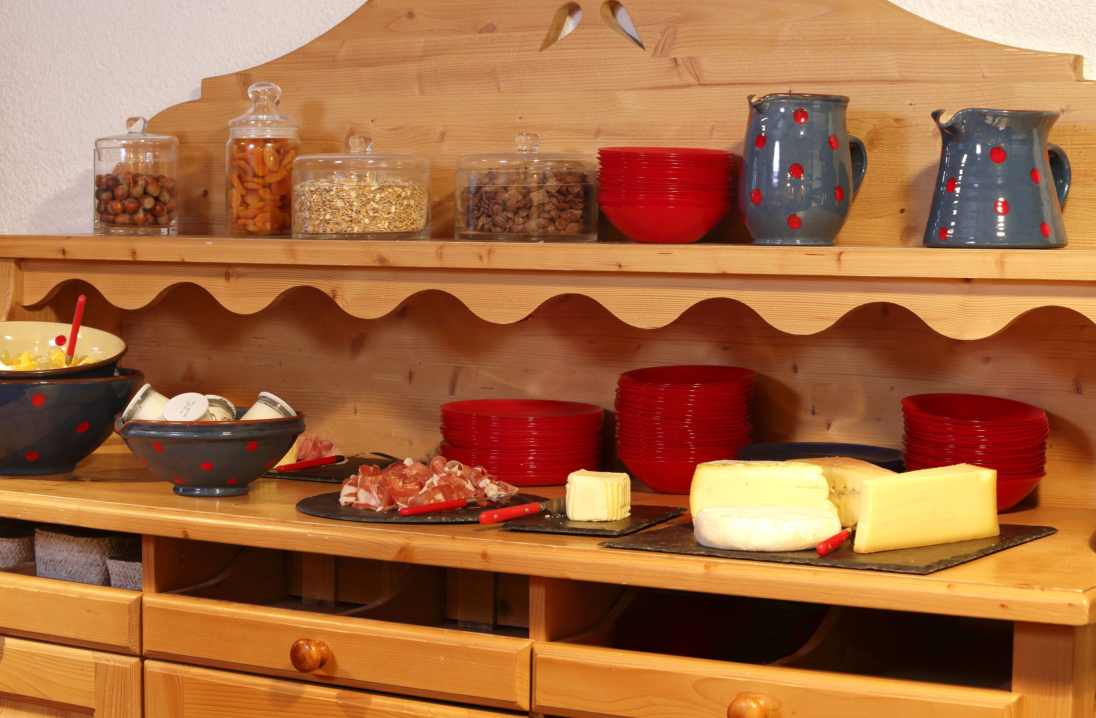 Una mesa buffet de madera con diversos alimentos y recipientes.