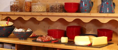 Una mesa buffet de madera con diversos alimentos y recipientes.