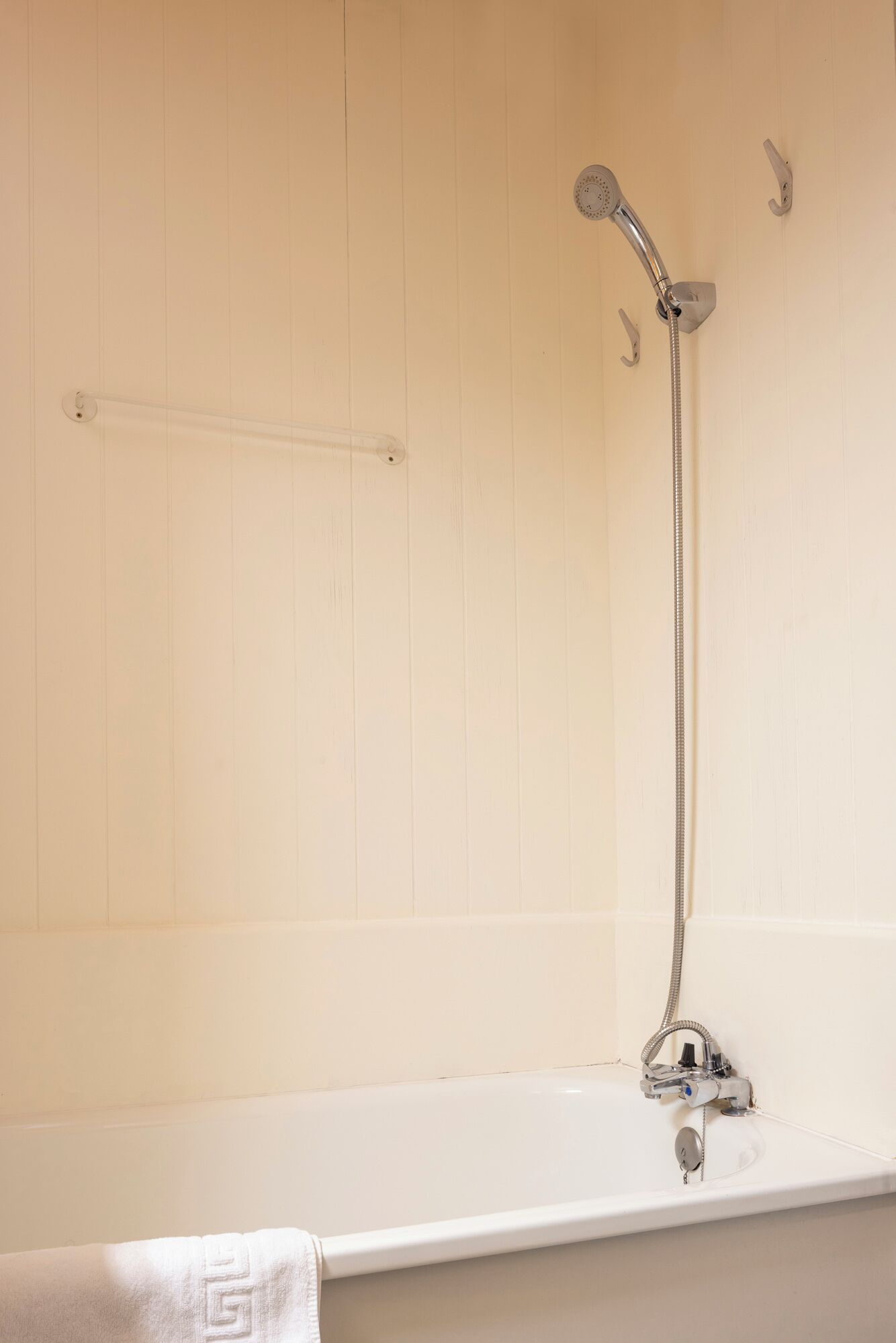 Une salle de bain avec une baignoire, une douche et un porte-serviettes.