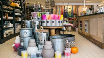 Loja com diversos recipientes metálicos e objetos decorativos em exposição.
