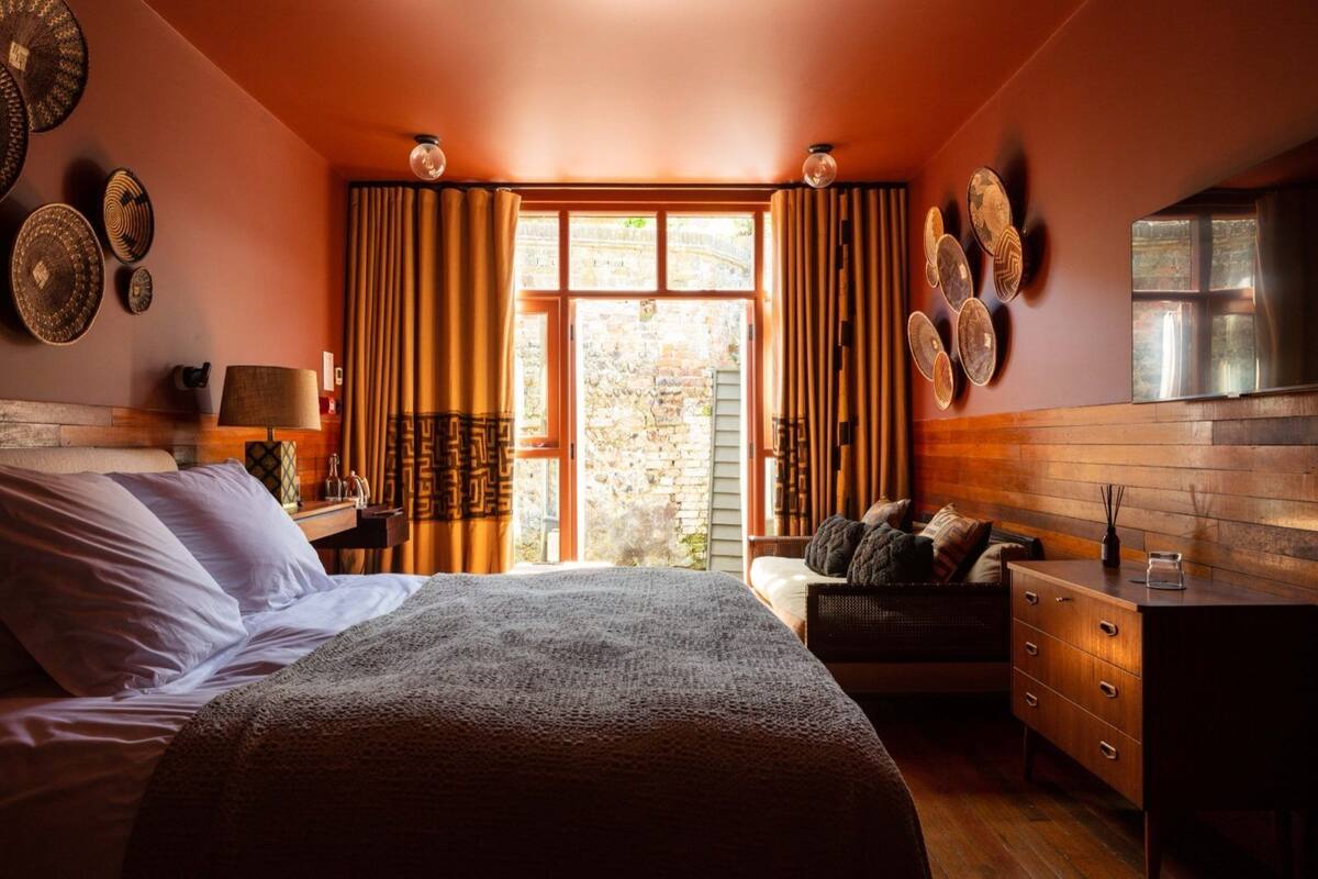 Un dormitorio con cama, escritorio y vistas al exterior.