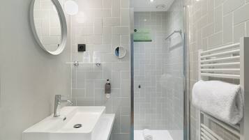 Une salle de bain moderne avec un lavabo, un miroir et une douche à parois en verre.