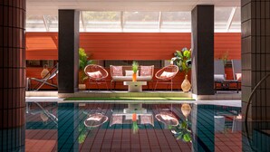 Área da piscina com espaço para sentar e vista para o exterior.