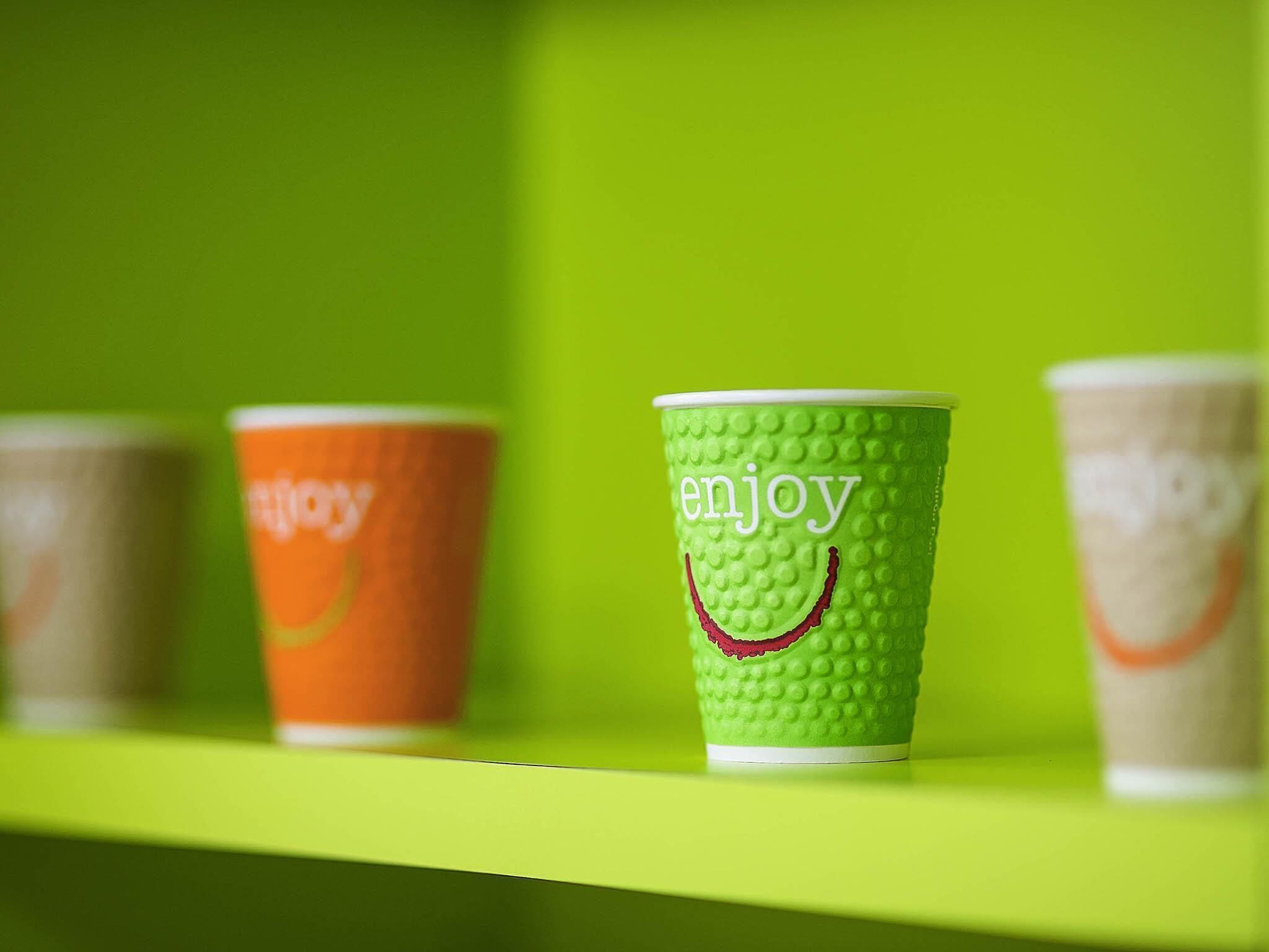 A row of paper cups on a shelf.