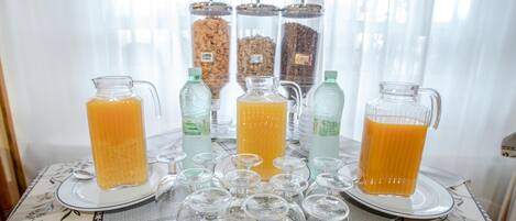 A breakfast buffet with various food and drink options, including cereal and juice.