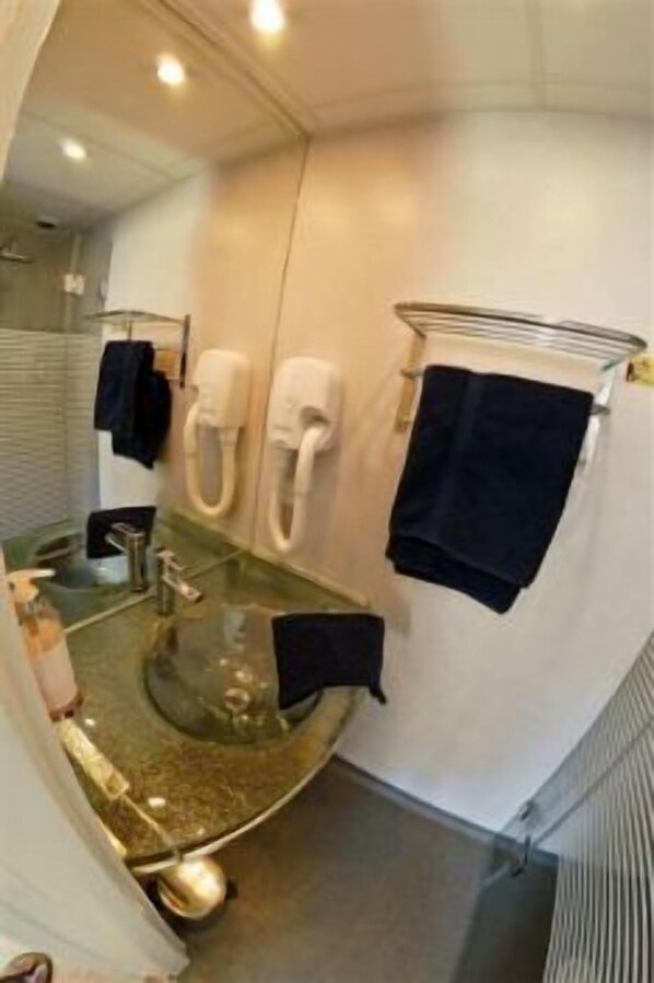 A bathroom with a curved vanity, a glass sink, a towel rack, and a toilet. - Le Cheval Blanc, Cognac Centre (Cognac)