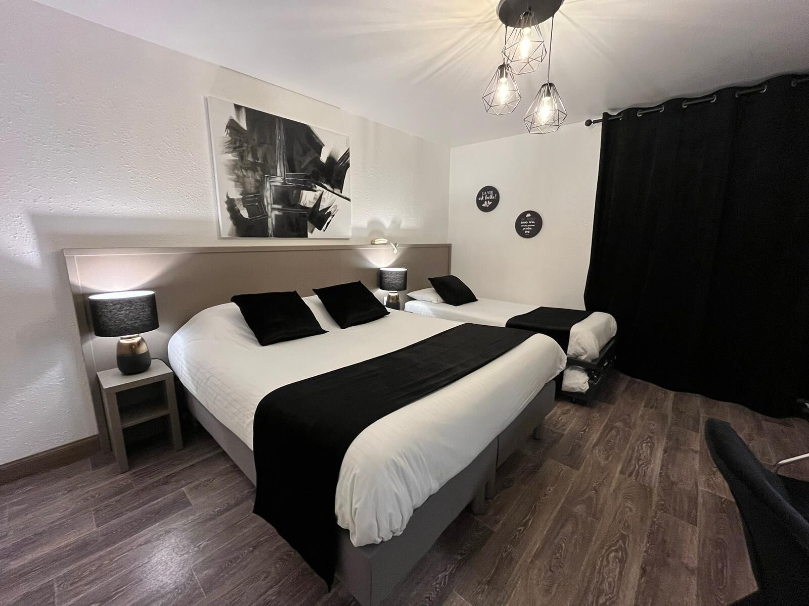 Une chambre d’hôtel moderne avec un grand lit, deux tables de chevet, un bureau et une chaise.
